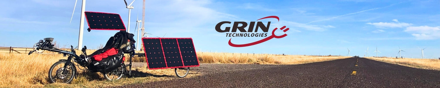Solar-powered vehicle with GRIN Technologies logo in a desert landscape