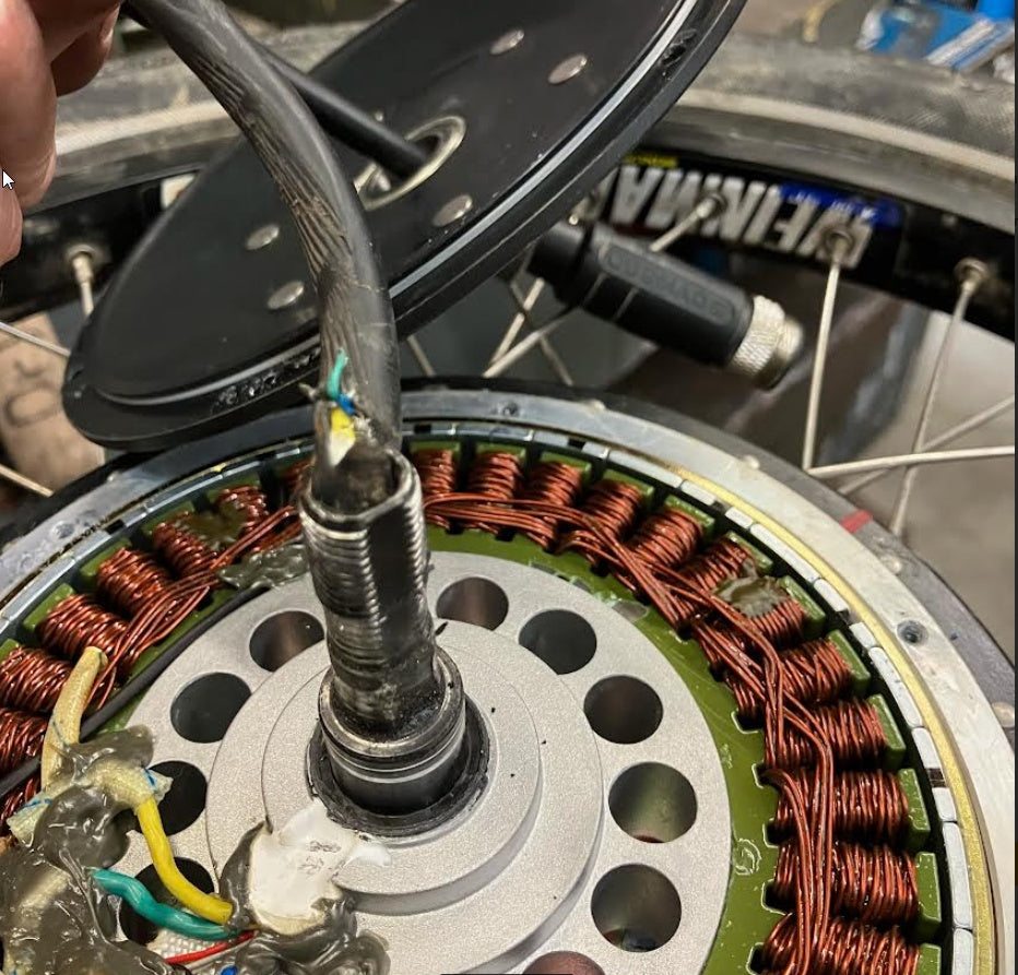 Close-up of a mechanical component with copper windings and wiring.